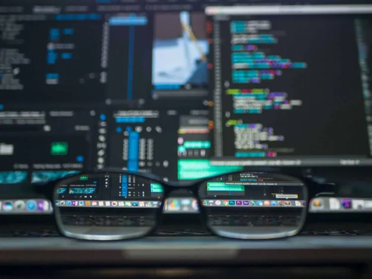eye glasses in front of computer monitors
