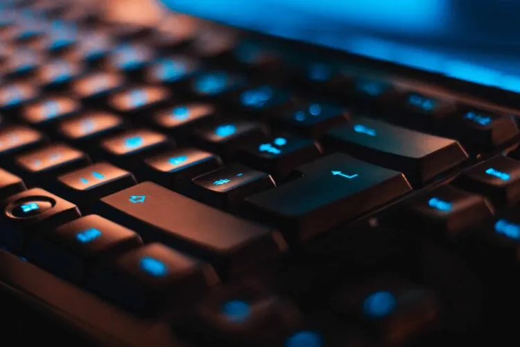 closeup of a black keyboard with eerie blue lighting