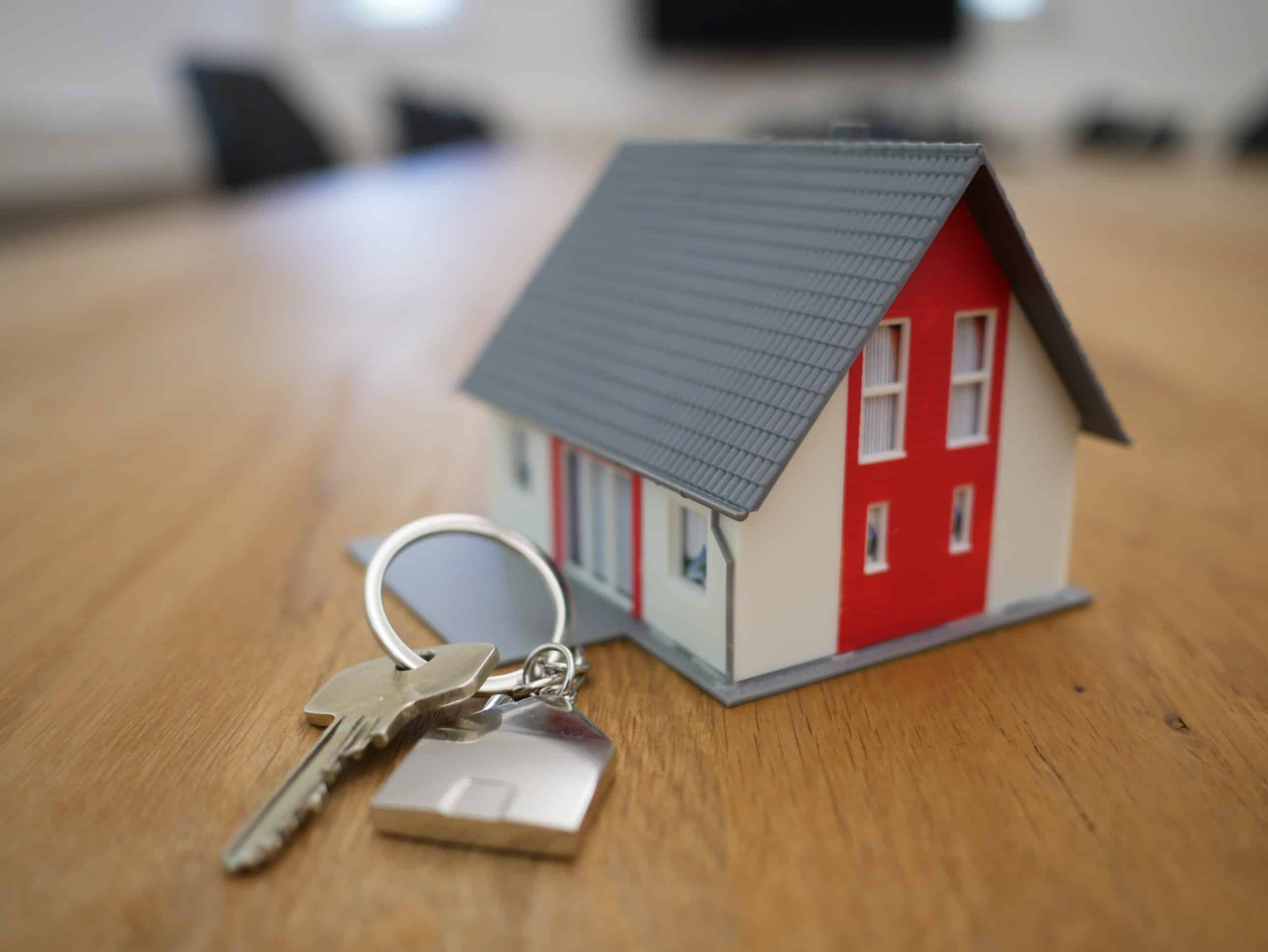 miniature house on a desk with a set of keys