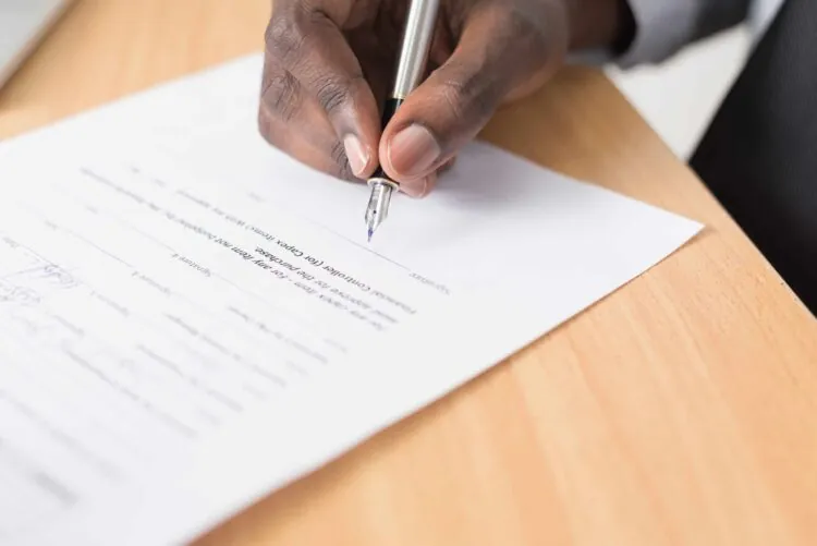 man signing legal document
