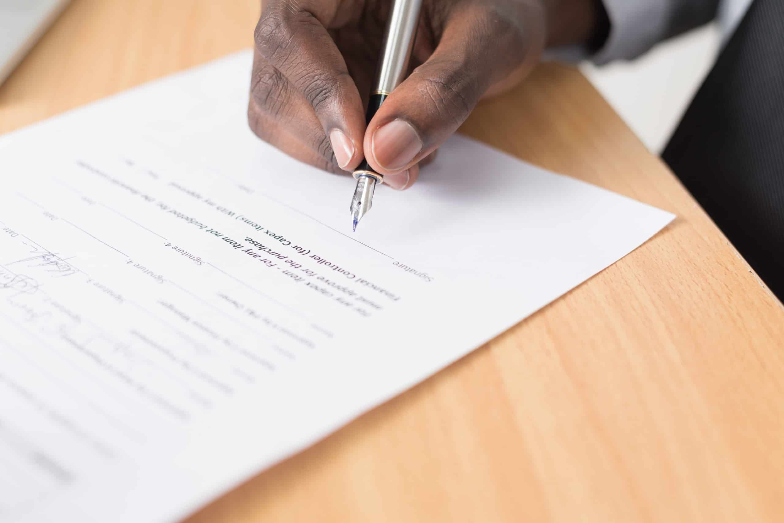 man signing legal document