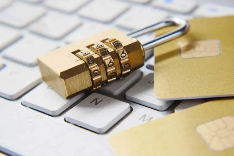 a combination lock and two credit cards on a laptop