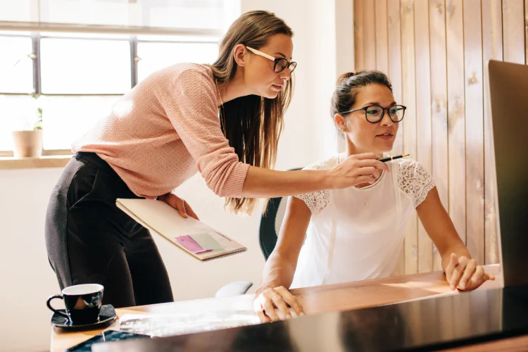 Two business women looking at computer