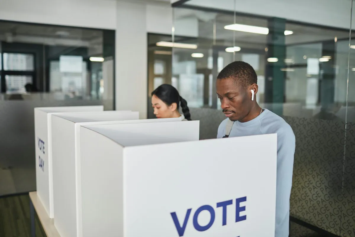 Two individuals cast their votes in an election