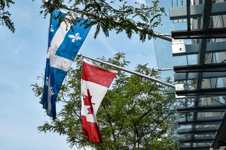 Quebec flag and Canada flag hang off building