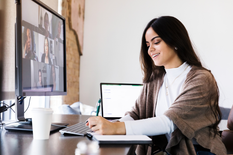 Woman takes notes while on Zoom call