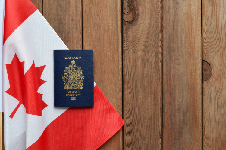 A photo of a Canadian flag and passport against a wooden table