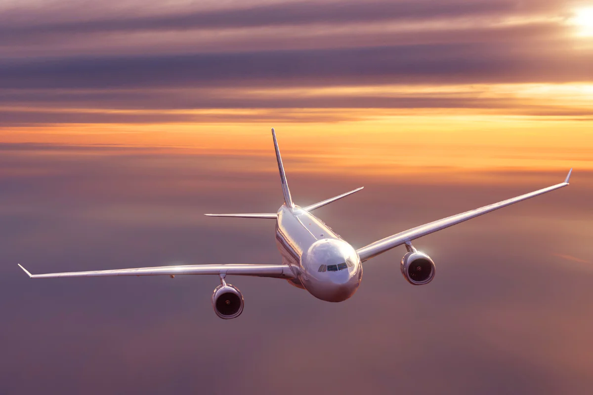 airplane flies in purple sky
