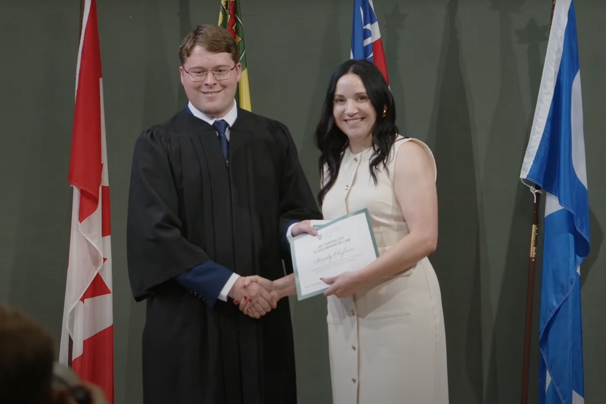 Law student Brody Olafson shaking hands with Erin Eccleston on stage