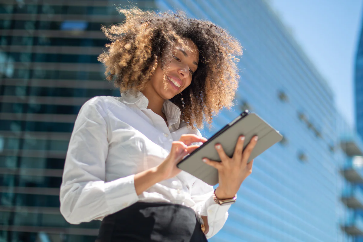 Business woman on tablet with office building in background