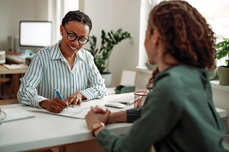 HR interviewing young businesswoman for a job at the modern office
