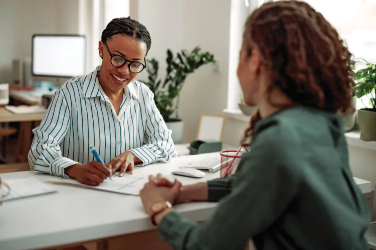 HR interviewing young businesswoman for a job at the modern office