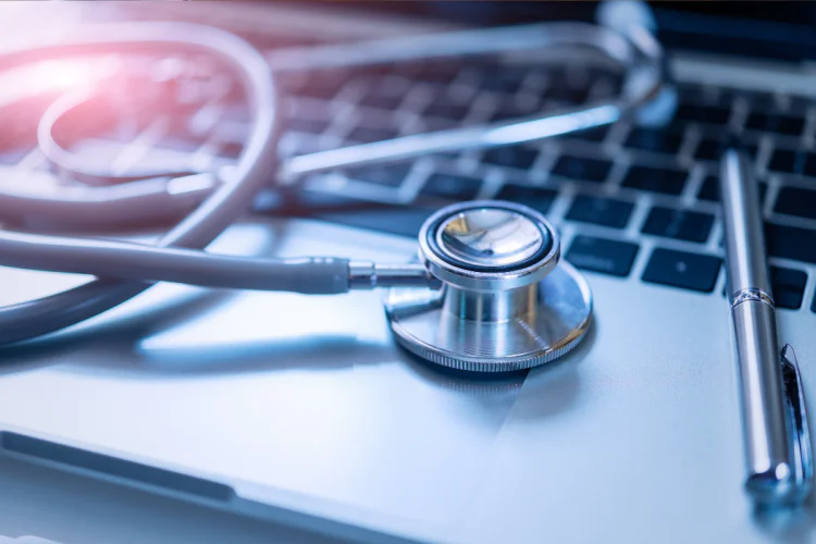A close-up photo of a stethoscope sitting on a laptop