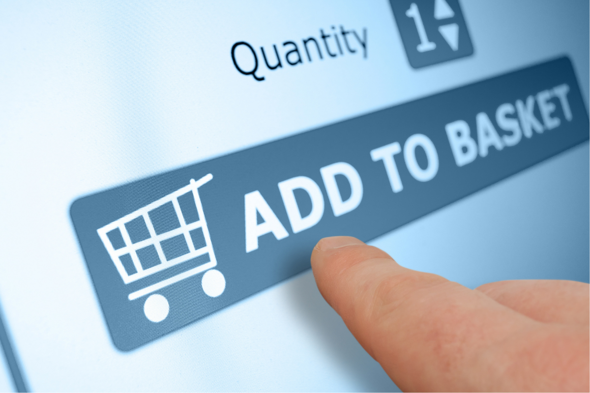 A closeup of a finger tapping an "Add to Basket" button on a computer screen