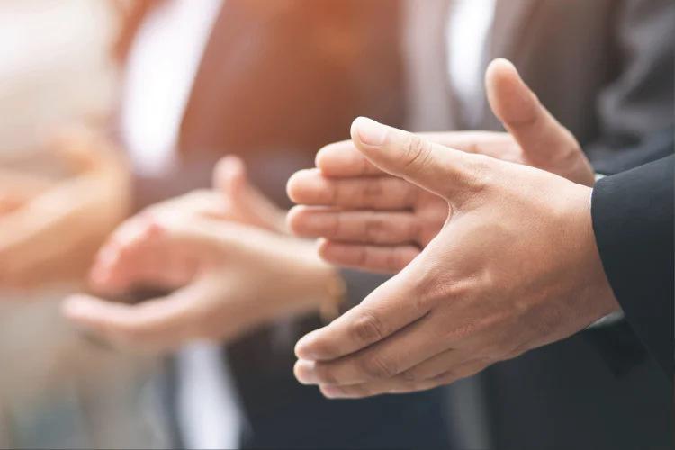 A group of people clapping, closeup on their hands