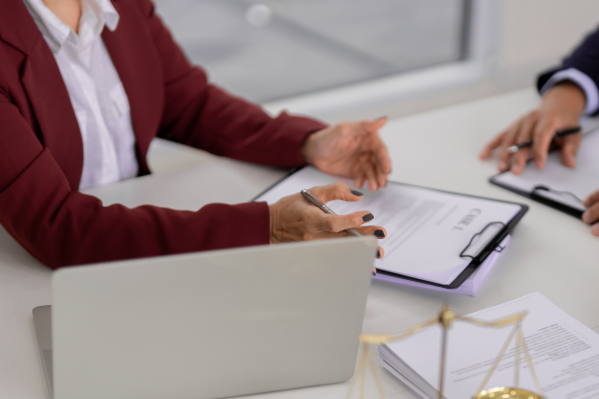 Two women in businesswear reviewing a document at a table
