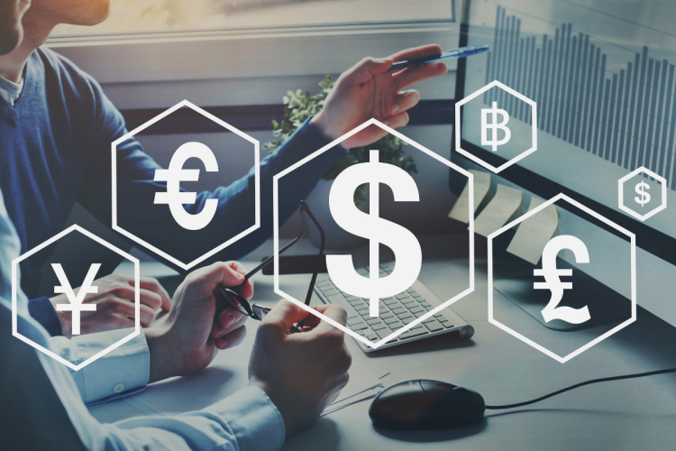 Foreign currency symbols overlaid on a background of two people looking at data on a computer screen