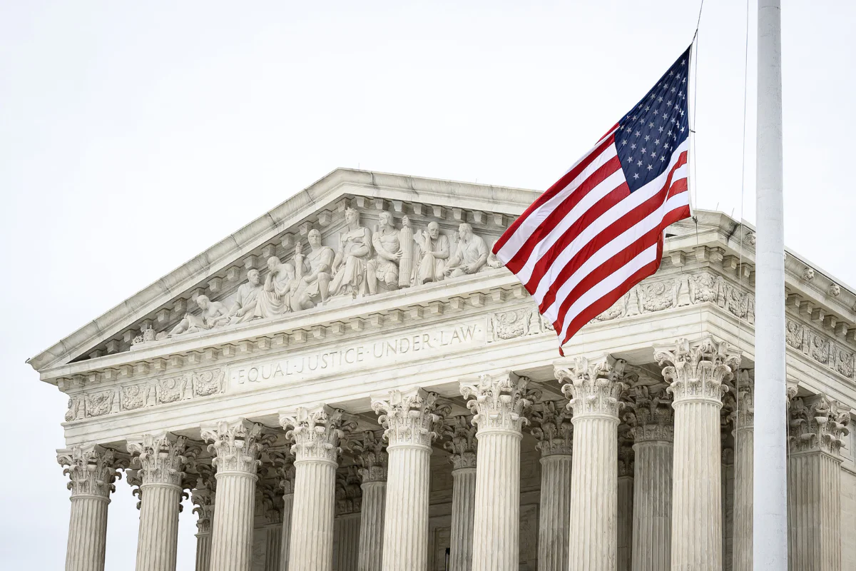 The U.S. Supreme Court Building, an American flag waving in front of it