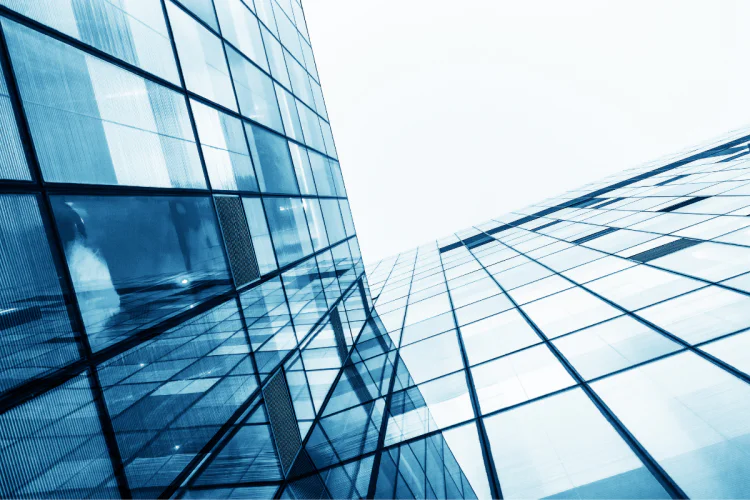 An upward view of skyscrapers against a grey sky