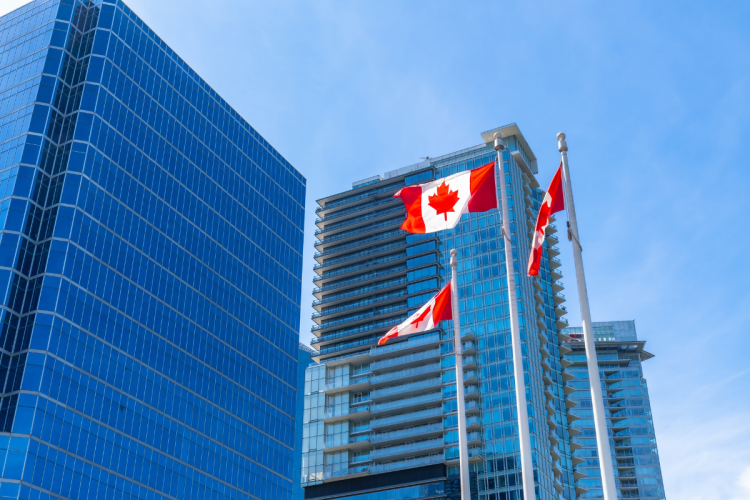 Canada flags flying outside of office buildings in downtown Vancouver, BC