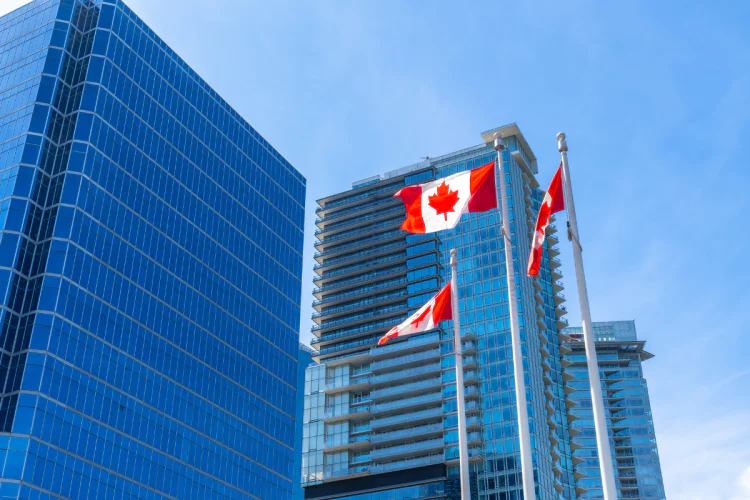 Canada flags flying outside of office buildings in downtown Vancouver, BC