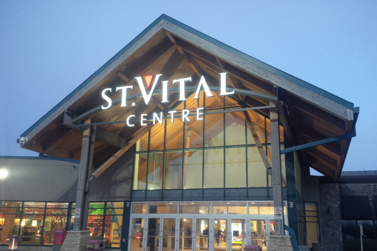 An external photo of St. Vital Centre's entrance in the evening