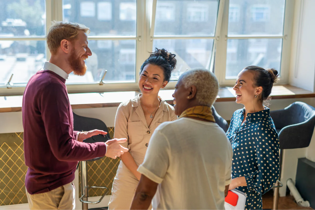 Diverse group of four co-workers stand in circle