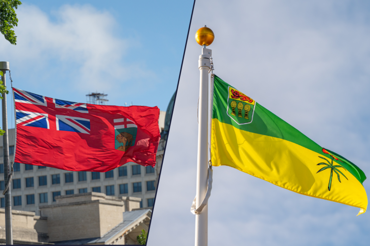 Manitoba and Saskatchewan flags against a blue sky
