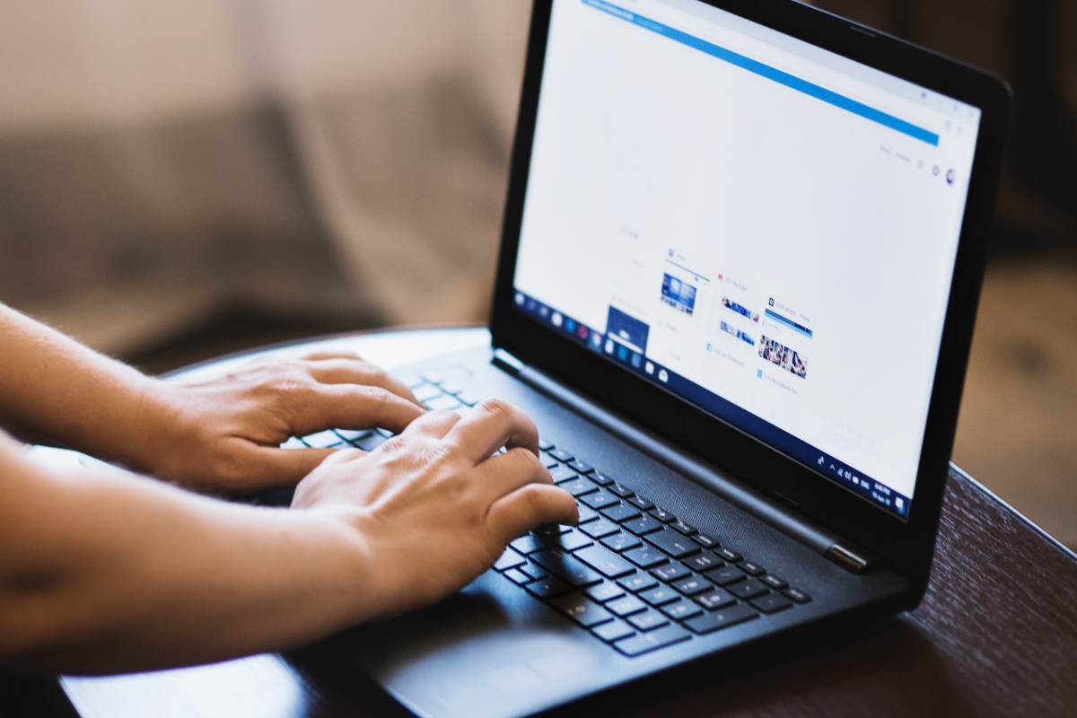 A closeup on someone using a laptop to post on social media