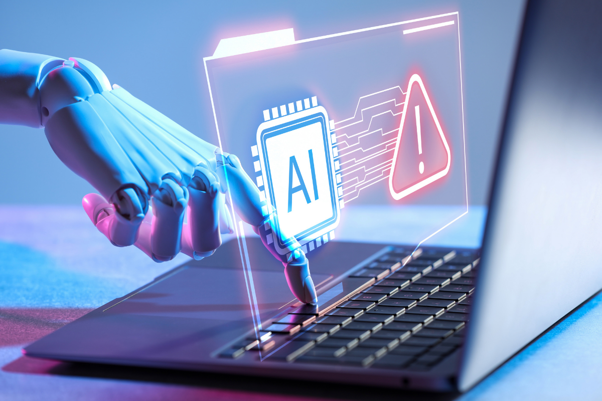 Robotic hand hits key on laptop, AI and ! alert overlayed