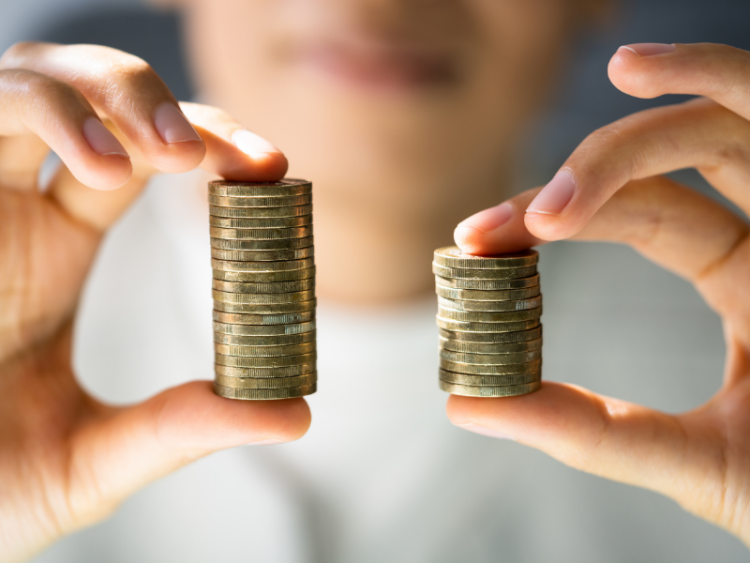 Someone holding two differently sized stacks of coins