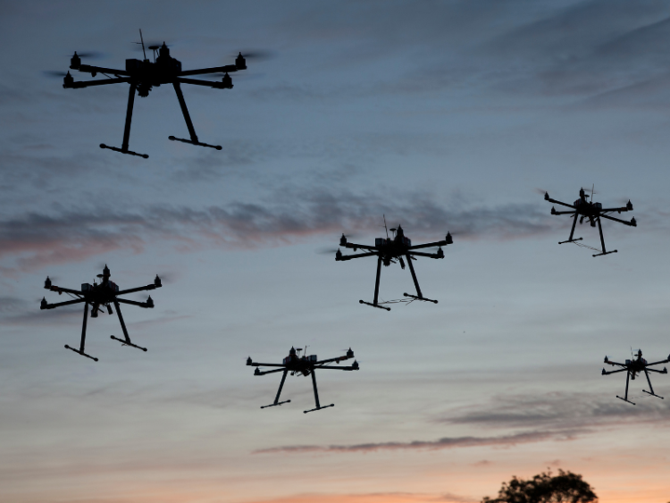 A fleet of drones at sunset