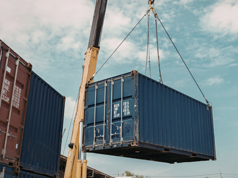 A shipping container being hoisted by a crane