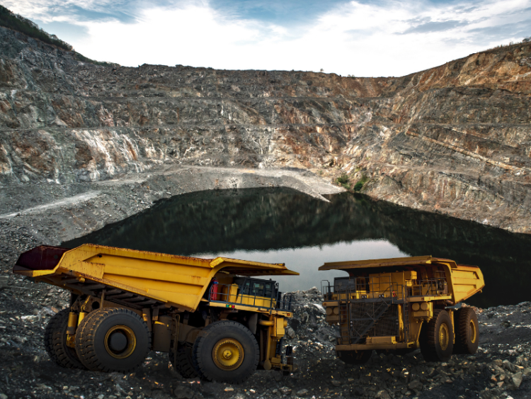 Two mining trucks at an open-air mining quarry