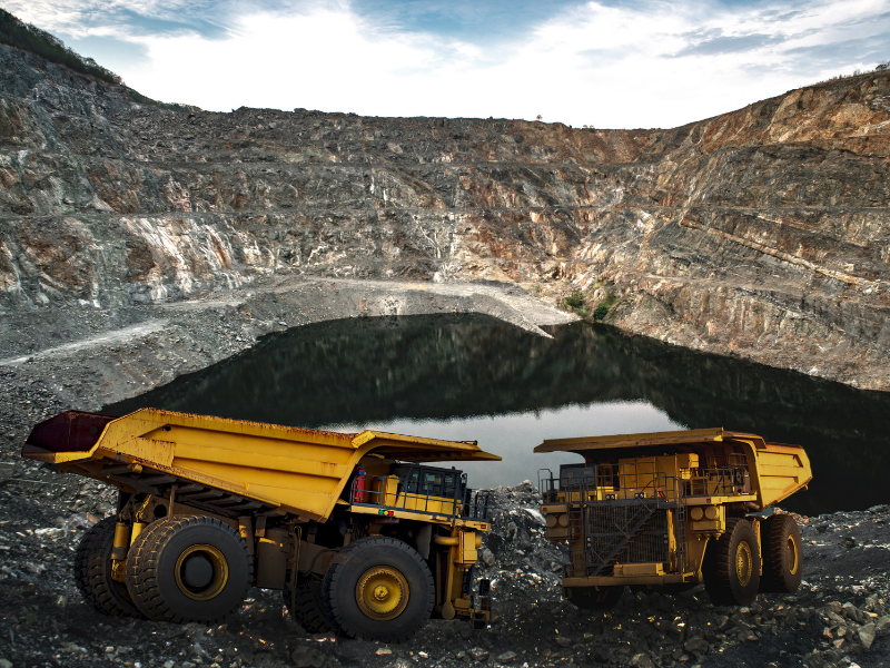 Two mining trucks at an open-air mining quarry