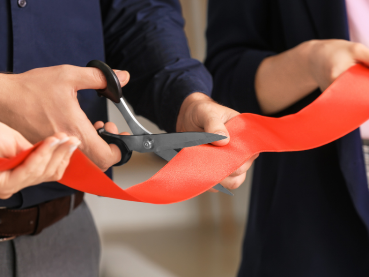 A close up shot of a ribbon cutting ceremony